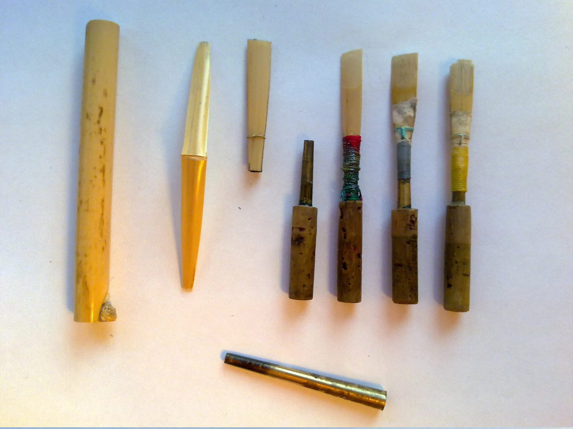 Oboe reeds at successive stages of making, from gouged and shaped cane to a finished reed